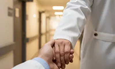 врач держит пациента за руку перед алкогольной детоксикацией